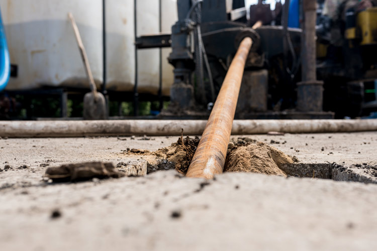 Close-up low-angle photograph showing horizontal directional drilling technology in action.
