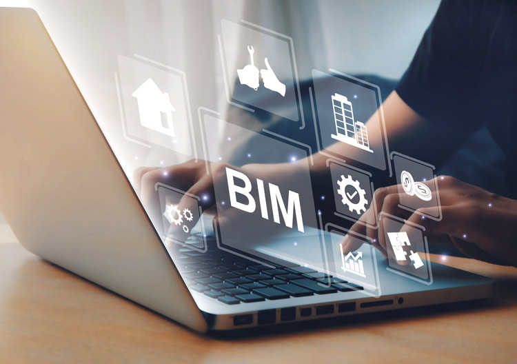 An engineer or business person works at a laptop with digital icons and interfaces floating above the screen.